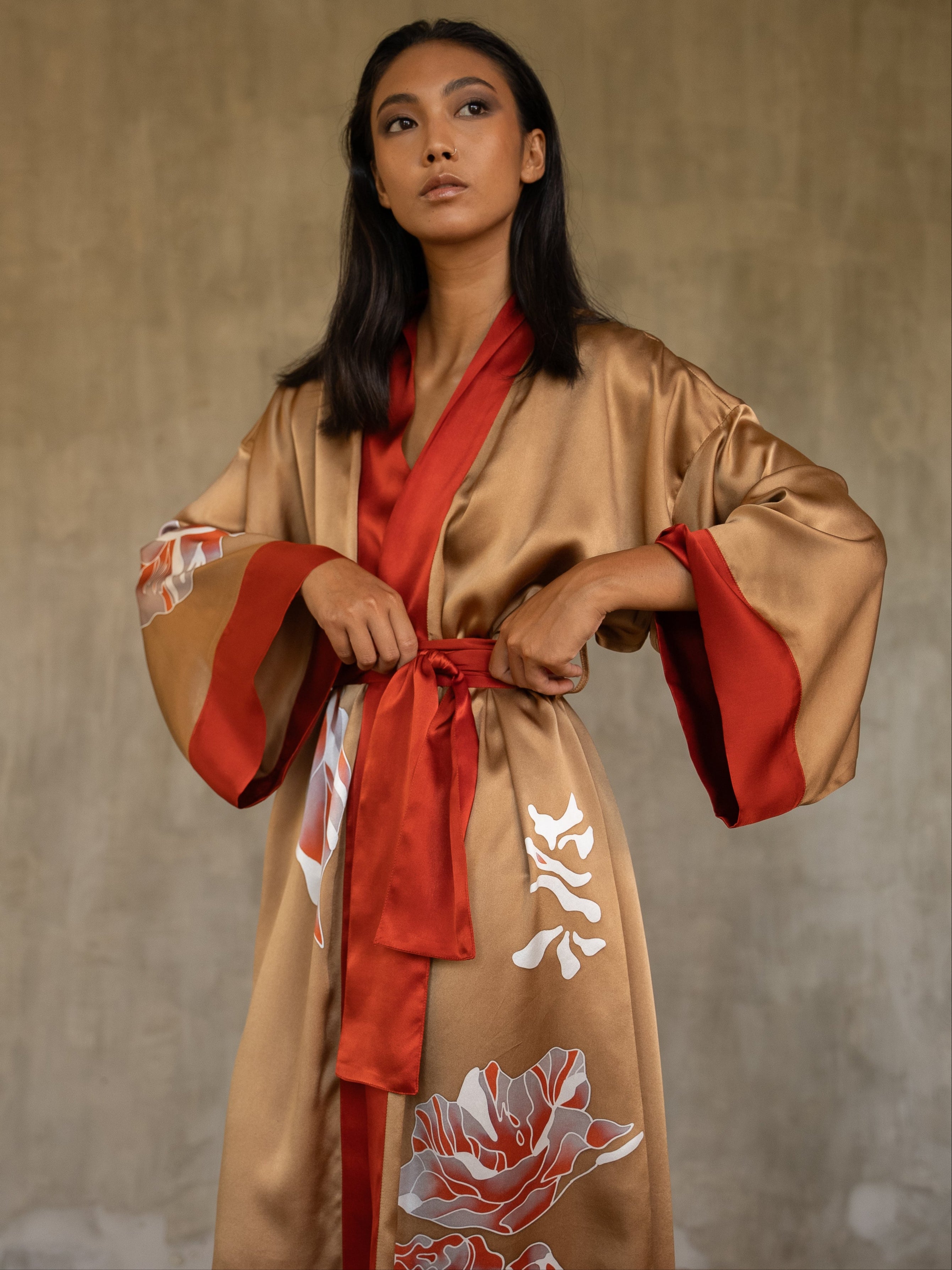 Quarzia signature Kimono has wide, flowing sleeves and it's handcrafted from pure silk satin. As Japanese style' kimono  it is open under the arms, and there's a bold border in contrast color on the cuffs and on the front. A beautiful silk belt also in contrast color frame this elegant piece, ultimate in relaxed style, elegance and comfort. The batik pattern is inspired by  flower and leaves. 