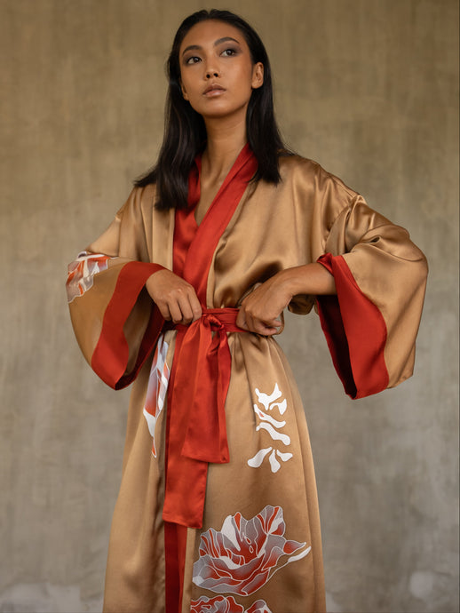 Quarzia signature Kimono has wide, flowing sleeves and it's handcrafted from pure silk satin. As Japanese style' kimono  it is open under the arms, and there's a bold border in contrast color on the cuffs and on the front. A beautiful silk belt also in contrast color frame this elegant piece, ultimate in relaxed style, elegance and comfort. The batik pattern is inspired by  flower and leaves. 