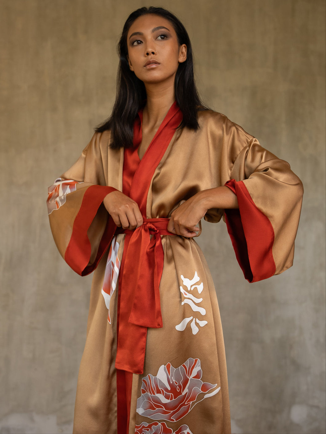 Quarzia signature Kimono has wide, flowing sleeves and it's handcrafted from pure silk satin. As Japanese style' kimono  it is open under the arms, and there's a bold border in contrast color on the cuffs and on the front. A beautiful silk belt also in contrast color frame this elegant piece, ultimate in relaxed style, elegance and comfort. The batik pattern is inspired by  flower and leaves. 