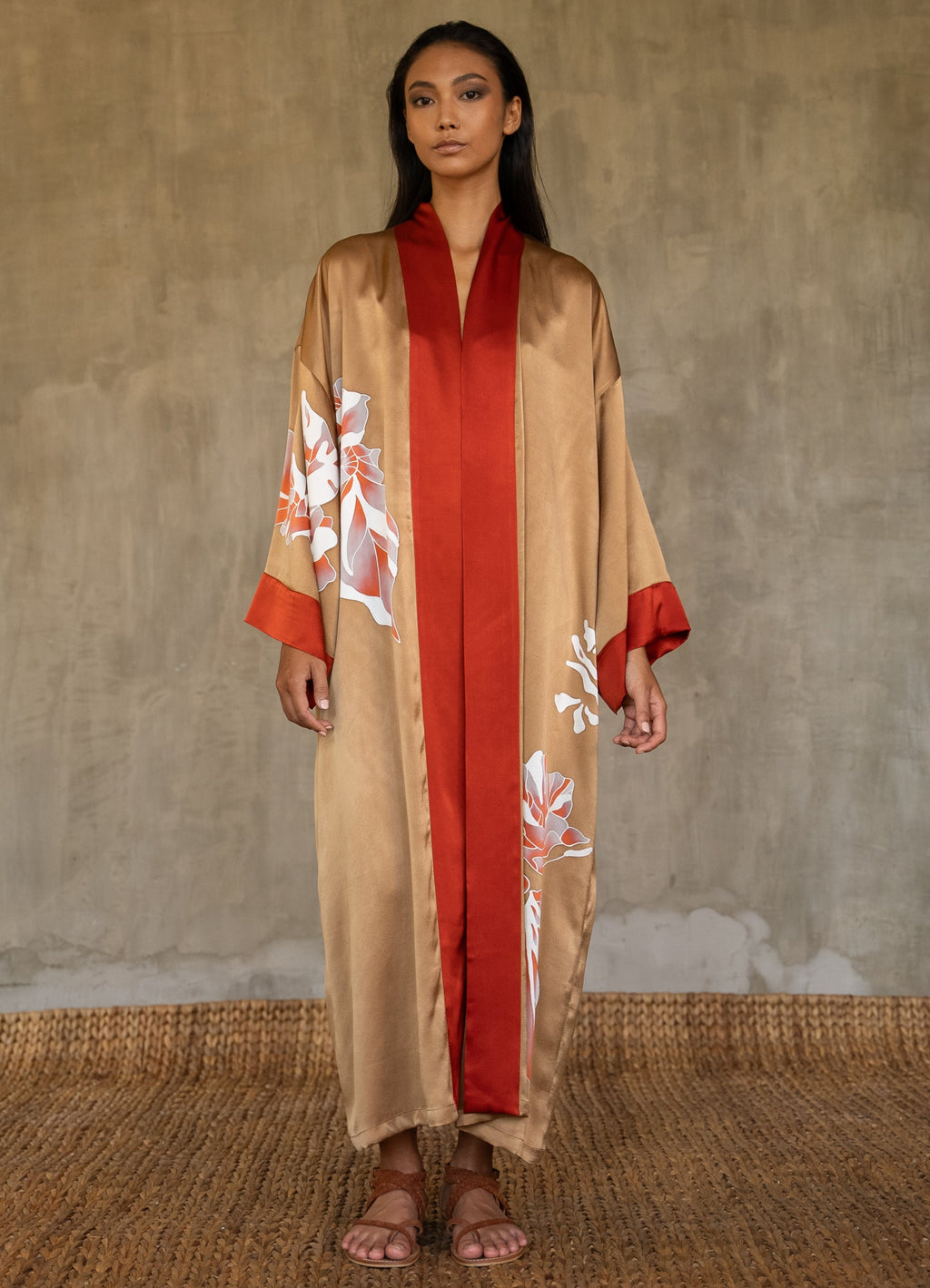 Quarzia signature Kimono has wide, flowing sleeves and it's handcrafted from pure silk satin. As Japanese style' kimono  it is open under the arms, and there's a bold border in contrast color on the cuffs and on the front. A beautiful silk belt also in contrast color frame this elegant piece, ultimate in relaxed style, elegance and comfort. The batik pattern is inspired by  flower and leaves. 