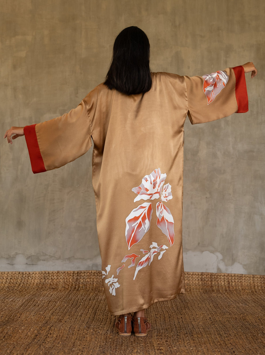 Back detail: Quarzia signature Kimono has wide, flowing sleeves and it's handcrafted from pure silk satin. As Japanese style' kimono  it is open under the arms, and there's a bold border in contrast color on the cuffs and on the front. A beautiful silk belt also in contrast color frame this elegant piece, ultimate in relaxed style, elegance and comfort. The batik pattern is inspired by  flower and leaves. 