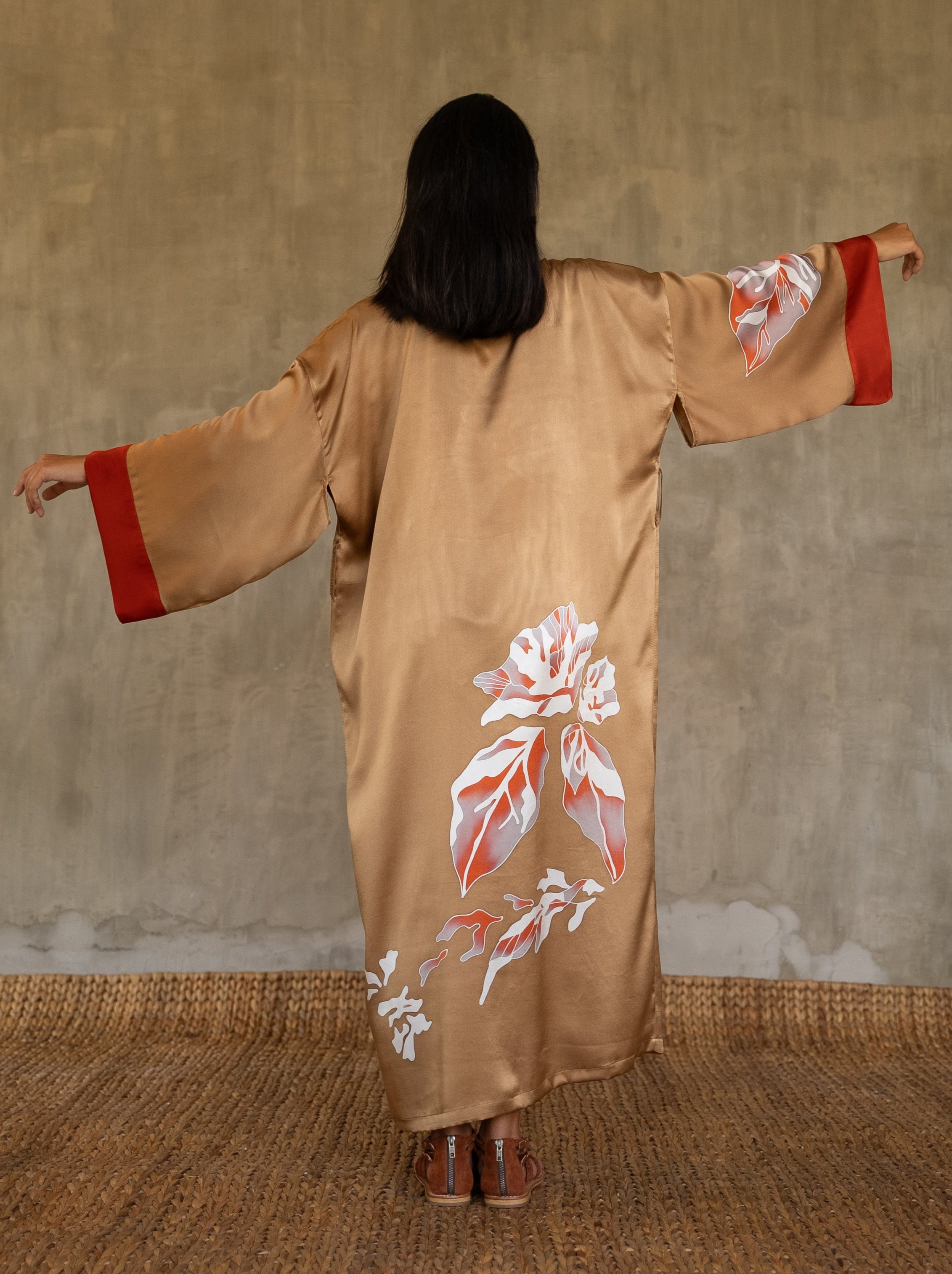 Back detail: Quarzia signature Kimono has wide, flowing sleeves and it's handcrafted from pure silk satin. As Japanese style' kimono  it is open under the arms, and there's a bold border in contrast color on the cuffs and on the front. A beautiful silk belt also in contrast color frame this elegant piece, ultimate in relaxed style, elegance and comfort. The batik pattern is inspired by  flower and leaves. 