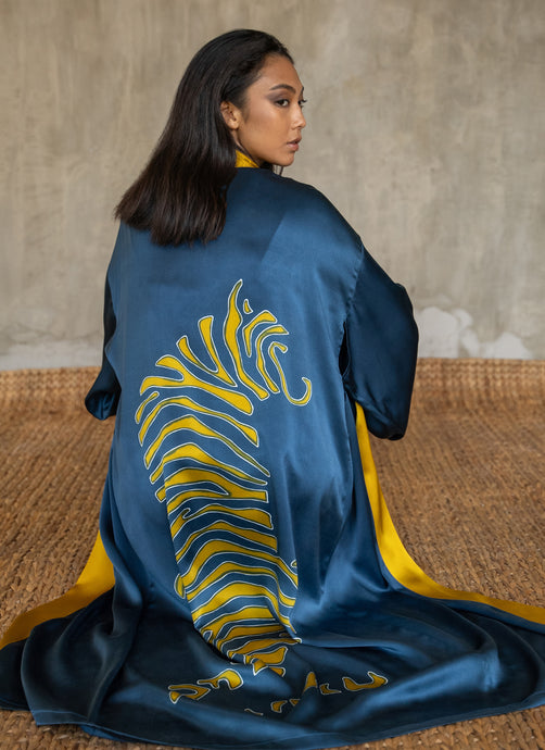 Quarzia signature Kimono has wide, flowing sleeves and it's handcrafted from pure silk satin. As Japanese style' kimono  it is open under the arms. A bold contrast color border on the cuffs and on the front, together with the same color silk belt, frame this elegant piece, ultimate in relaxed style, elegance and comfort. The batik pattern is inspired by the stillness pose of a tiger.