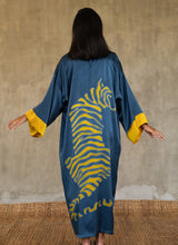 Load image into Gallery viewer, Back detail: Quarzia signature Kimono has wide, flowing sleeves and it&#39;s handcrafted from pure silk satin. As Japanese style&#39; kimono  it is open under the arms. A bold contrast color border on the cuffs and on the front, together with the same color silk belt, frame this elegant piece, ultimate in relaxed style, elegance and comfort. The batik pattern is inspired by the stillness pose of a tiger.
