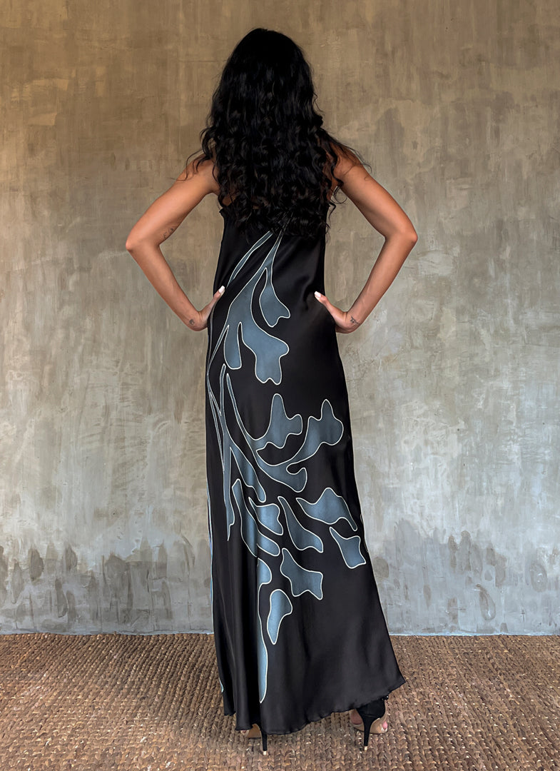 Back detail: Silk satin handcrafted long spaghetti dress in black with maxi foliage pattern front and back. Bias cut dress with low V-neckline.