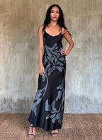 Silk satin handcrafted long spaghetti dress in black with maxi foliage pattern front and back. Bias cut dress with low V-neckline.