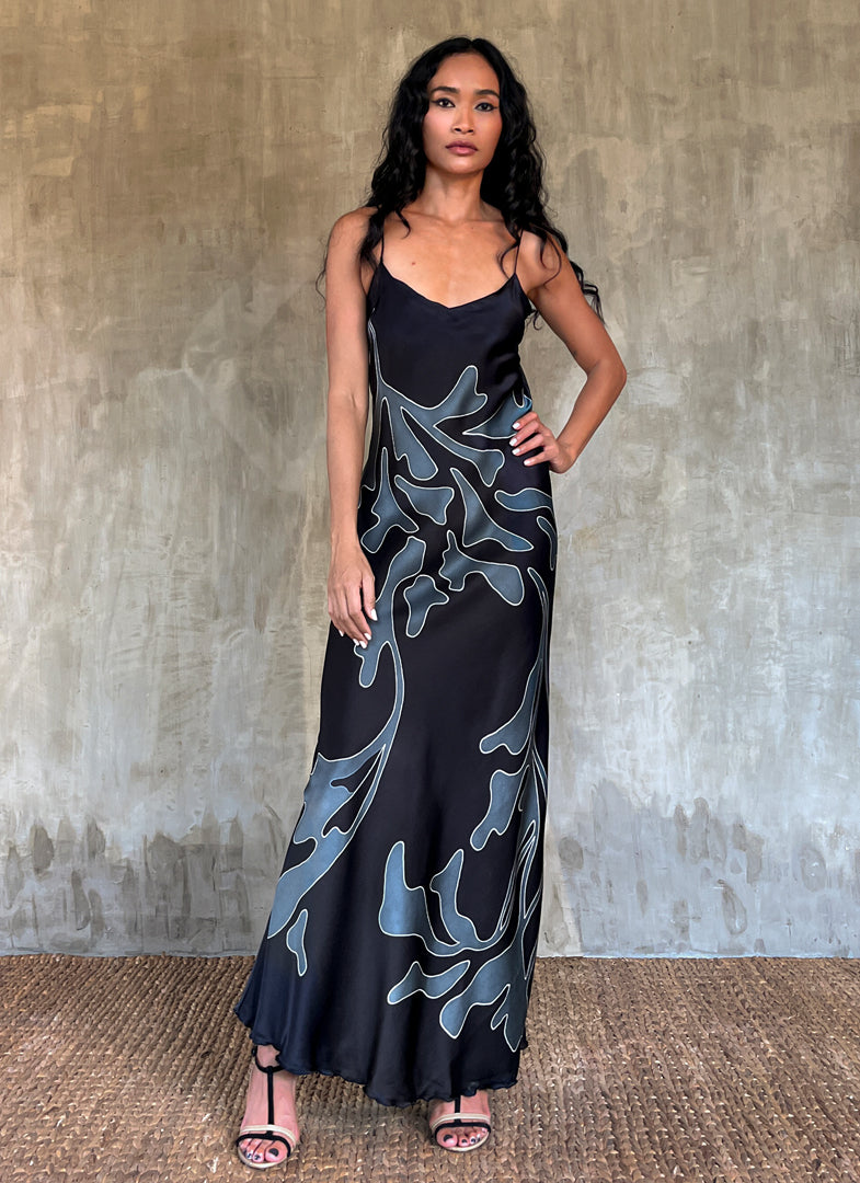 Silk satin handcrafted long spaghetti dress in black with maxi foliage pattern front and back. Bias cut dress with low V-neckline.