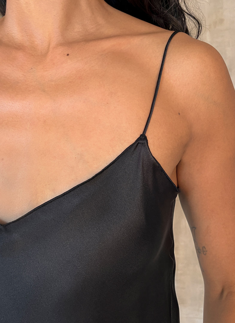 Detail of shoulder: Silk satin handcrafted long spaghetti dress in black with maxi foliage pattern front and back. Bias cut dress with low V-neckline.