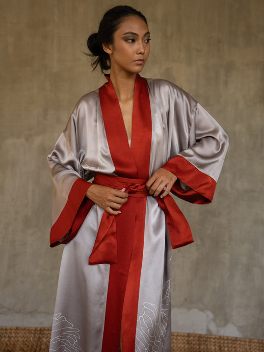Quarzia signature Kimono has wide, flowing sleeves and it's handcrafted from pure silk satin. As Japanese style' kimono  it is open under the arms. A bold contrast color border on the cuffs and on the front, together with the same color silk belt, frame this elegant piece, ultimate in relaxed style, elegance and comfort. The batik pattern is inspired by the beauty of imperfection in nature.