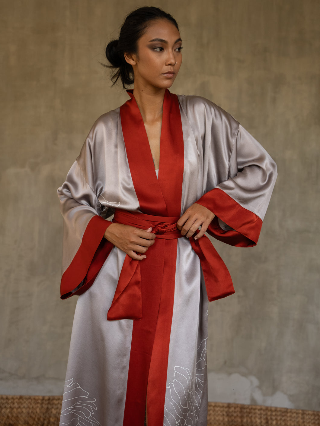 Quarzia signature Kimono has wide, flowing sleeves and it's handcrafted from pure silk satin. As Japanese style' kimono  it is open under the arms. A bold contrast color border on the cuffs and on the front, together with the same color silk belt, frame this elegant piece, ultimate in relaxed style, elegance and comfort. The batik pattern is inspired by the beauty of imperfection in nature.