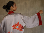 Quarzia signature Kimono has wide, flowing sleeves and it's handcrafted from pure silk satin. As Japanese style' kimono  it is open under the arms. A bold contrast color border on the cuffs and on the front, together with the same color silk belt, frame this elegant piece, ultimate in relaxed style, elegance and comfort. The batik pattern is inspired by the beauty of imperfection in nature.