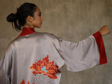 Load image into Gallery viewer, Quarzia signature Kimono has wide, flowing sleeves and it&#39;s handcrafted from pure silk satin. As Japanese style&#39; kimono  it is open under the arms. A bold contrast color border on the cuffs and on the front, together with the same color silk belt, frame this elegant piece, ultimate in relaxed style, elegance and comfort. The batik pattern is inspired by the beauty of imperfection in nature.
