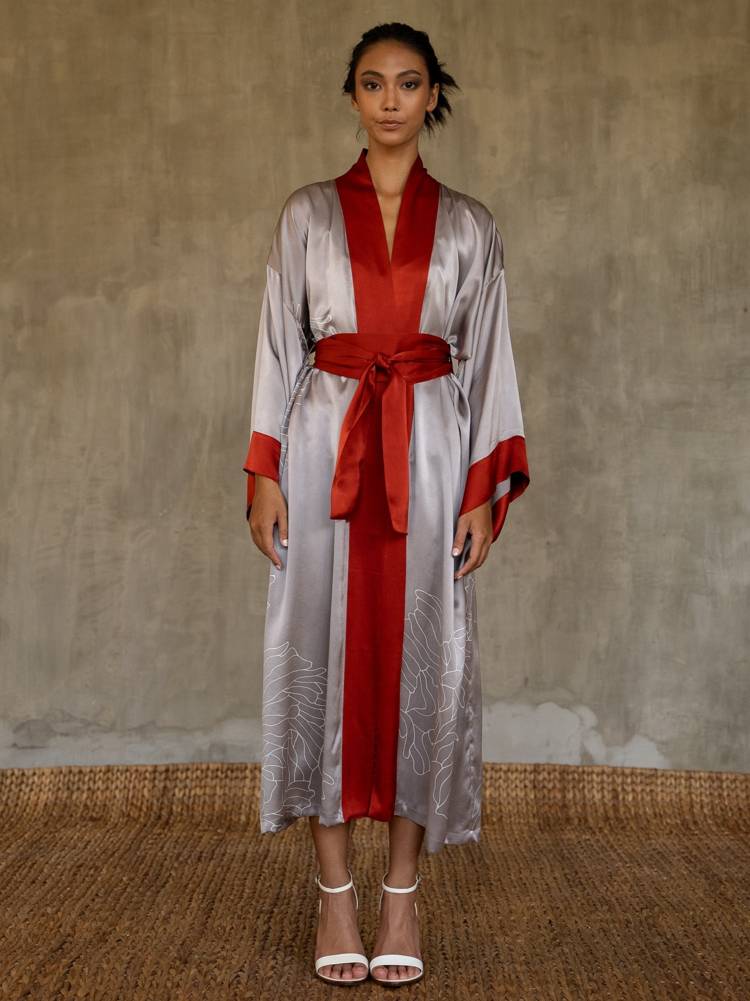 Quarzia signature Kimono has wide, flowing sleeves and it's handcrafted from pure silk satin. As Japanese style' kimono  it is open under the arms. A bold contrast color border on the cuffs and on the front, together with the same color silk belt, frame this elegant piece, ultimate in relaxed style, elegance and comfort. The batik pattern is inspired by the beauty of imperfection in nature.