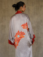 Back detail: Quarzia signature Kimono has wide, flowing sleeves and it's handcrafted from pure silk satin. As Japanese style' kimono  it is open under the arms. A bold contrast color border on the cuffs and on the front, together with the same color silk belt, frame this elegant piece, ultimate in relaxed style, elegance and comfort. The batik pattern is inspired by the beauty of imperfection in nature.