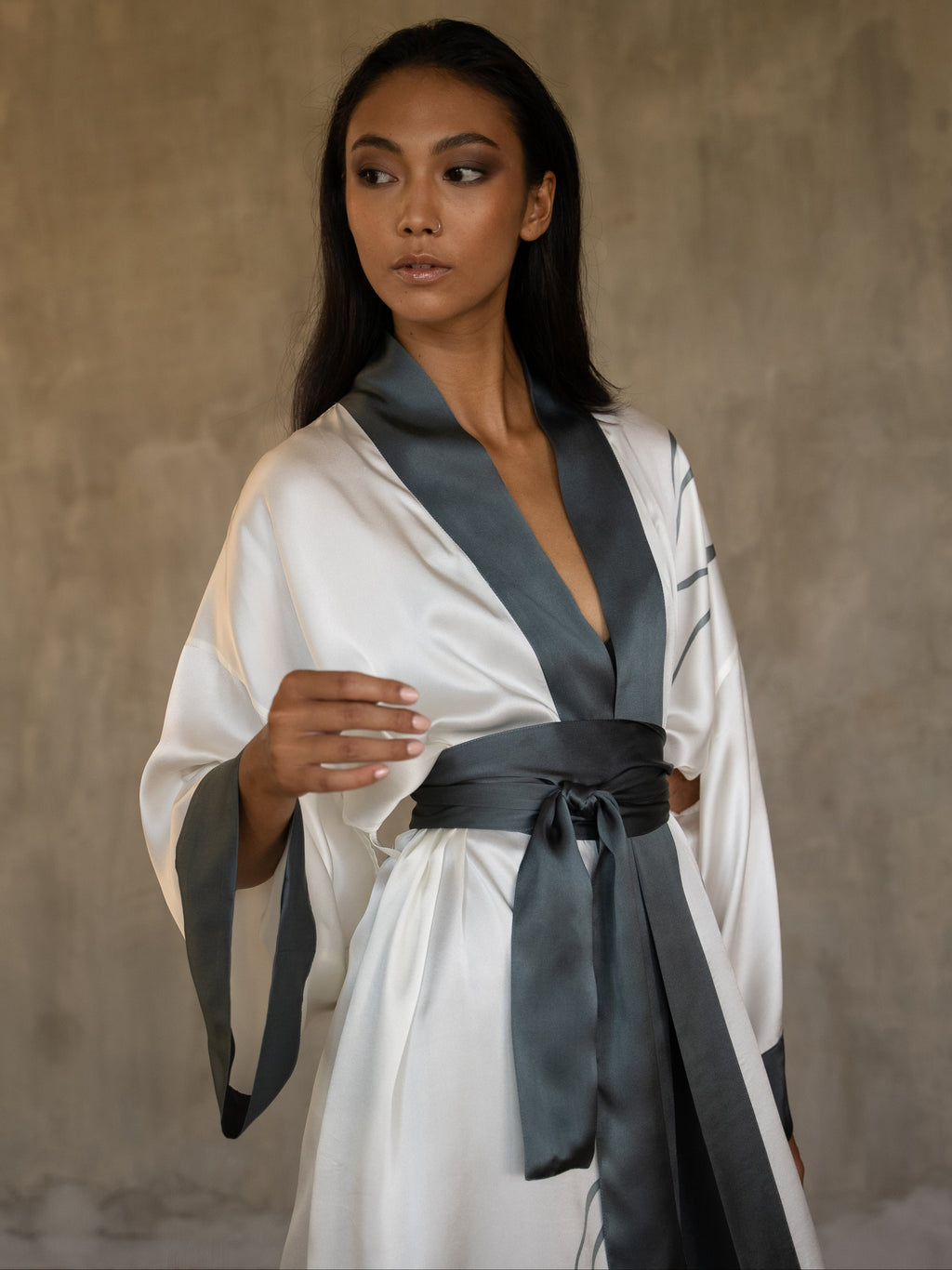 Top front detail: Quarzia signature Kimono has wide, flowing sleeves and it's handcrafted from pure silk satin. As Japanese style' kimono  it is open under the arms, and there's a bold border on the cuffs and on the front. A beautiful silk belt frame this elegant piece, ultimate in relaxed style, elegance and comfort. The batik pattern is inspired by Kintsugi Japanese technique to fix the broken ceramics.
