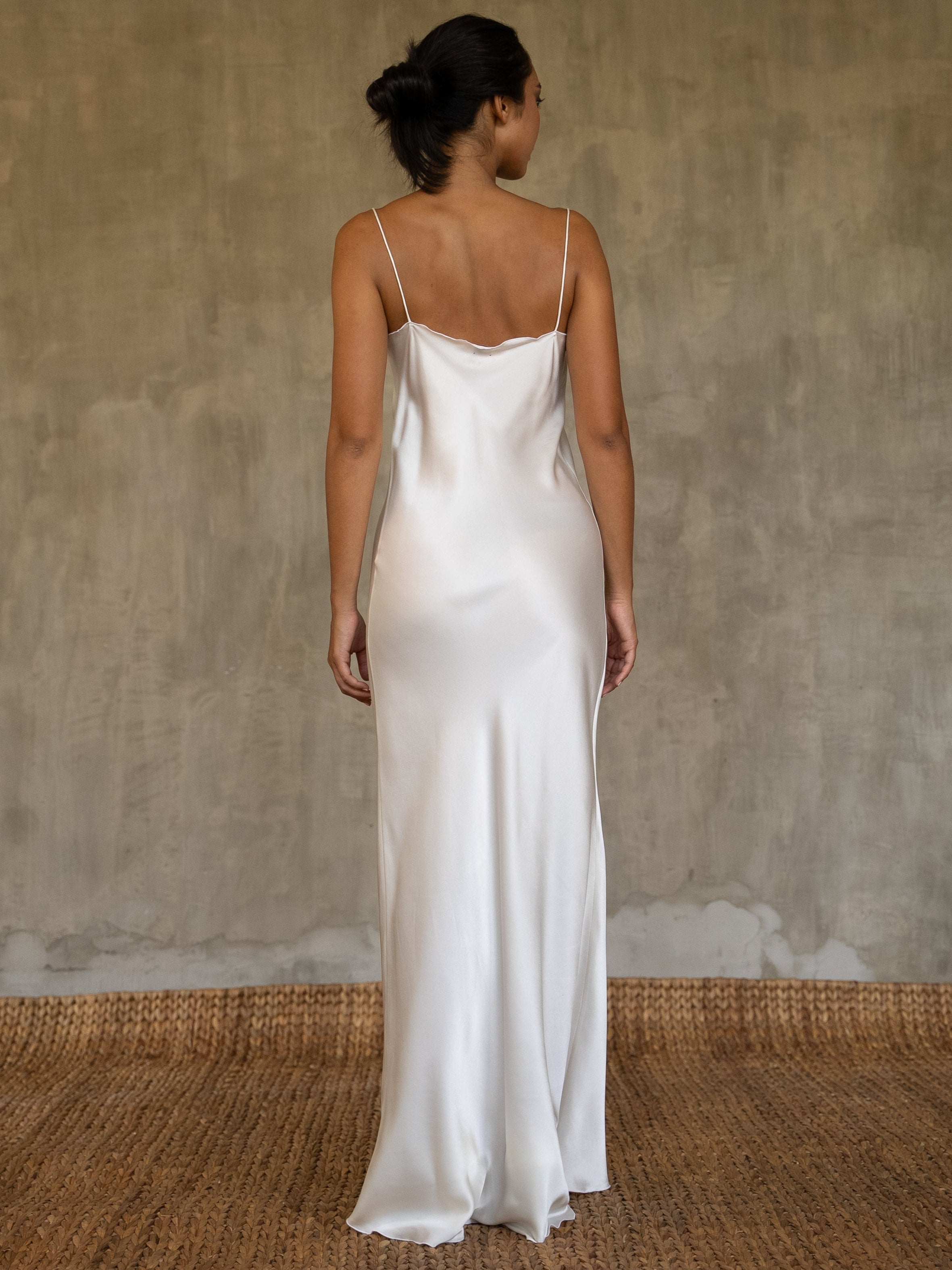 Back detail: this full length slip dress is cut on the bias, allowing a natural drape on the body which is complimented by the delicate spaghetti straps and the gentle, low-cut V-neckline. 