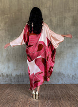 Load image into Gallery viewer, Back detail- Silk satin handpainted asymmetric long dress in Greenwall botanical pattern in light pink background and darker pink leaves .
