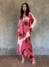 Load image into Gallery viewer, Silk satin handpainted asymmetric long dress in Greenwall botanical pattern in light pink background and darker pink leaves .
