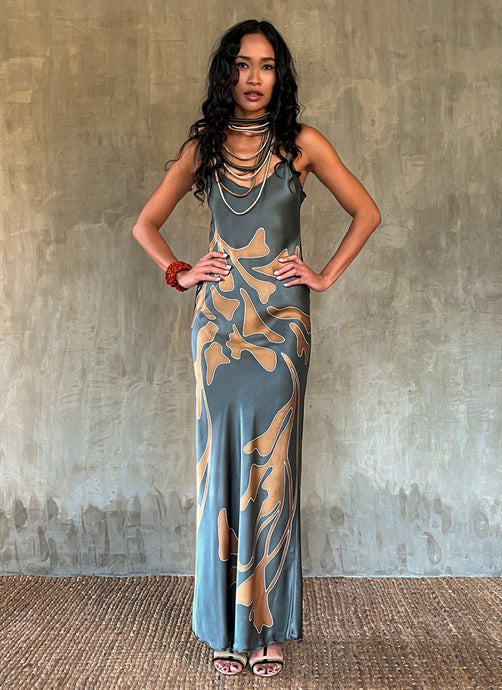 Silk satin handcrafted bias long spaghetti dress in steel grey with maxi foliage pattern front and back. Bias cut dress with low V-neckline.