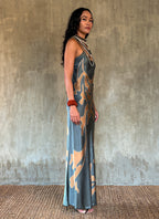 Side detail: silk satin handcrafted bias long spaghetti dress in steel grey with maxi foliage pattern front and back. Bias cut dress with low V-neckline.
