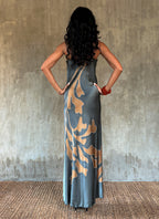 Back detail: Silk satin handcrafted bias long spaghetti dress in steel grey with maxi foliage pattern front and back. Bias cut dress with low V-neckline.