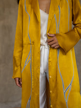 Load image into Gallery viewer, Front detail: hand-crafted in glossy pure silk, this jacket&#39; neck-line dress it has elegant, structured trumpet cuffs,   discreet pockets and waist drawstring add to the sophistication and comfort. The stunning gold colour is set-off by the contemporary hand-painted Kintsugi design, inspired by the Japanese technique for broken ceramics.
