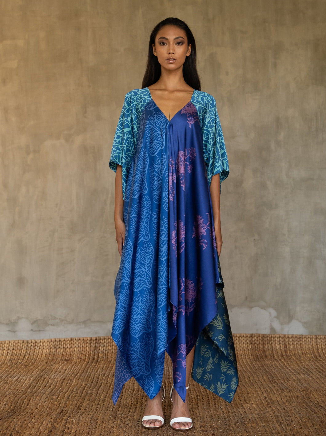 Quarzia artisanal silk satin blue Ally dress is a celebration of modern batik patterns. Multiple designs, inspired by nature, are hand-crafted on silk in various hues of blue. The generous silhouette will suite all sizes. Made in Bali.