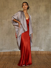Load image into Gallery viewer, This full length slip dress is cut on the bias, allowing a natural drape on the body which is complimented by the delicate spaghetti straps and the gentle, low-cut V-neckline.  Wore here with  beautiful batik open coat .
