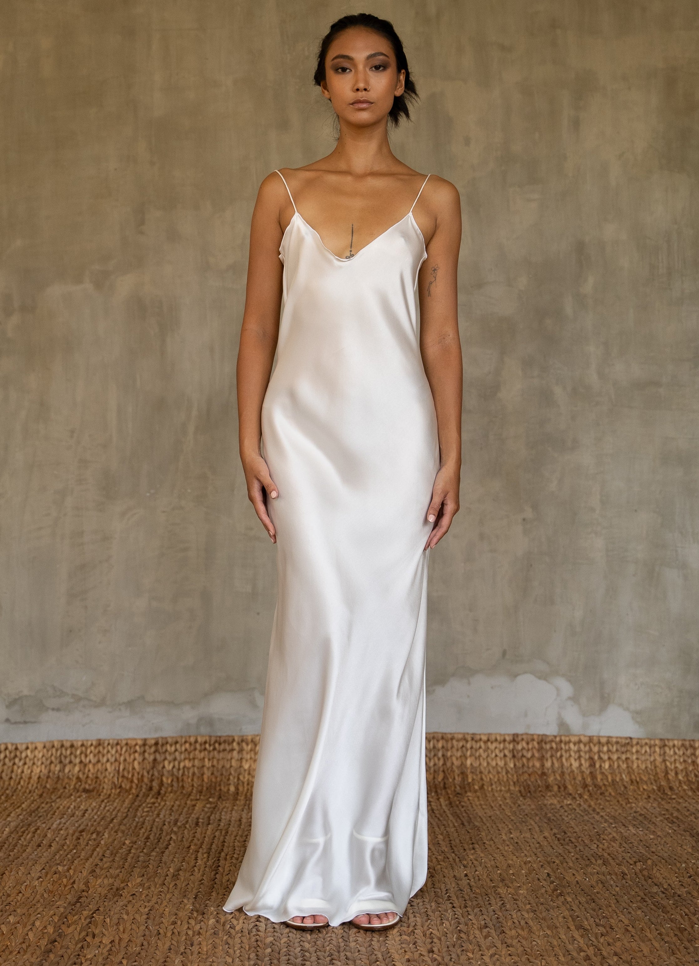 This full length slip dress is cut on the bias, allowing a natural drape on the body which is complimented by the delicate spaghetti straps and the gentle, low-cut V-neckline. 