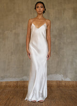 Load image into Gallery viewer, This full length slip dress is cut on the bias, allowing a natural drape on the body which is complimented by the delicate spaghetti straps and the gentle, low-cut V-neckline. 
