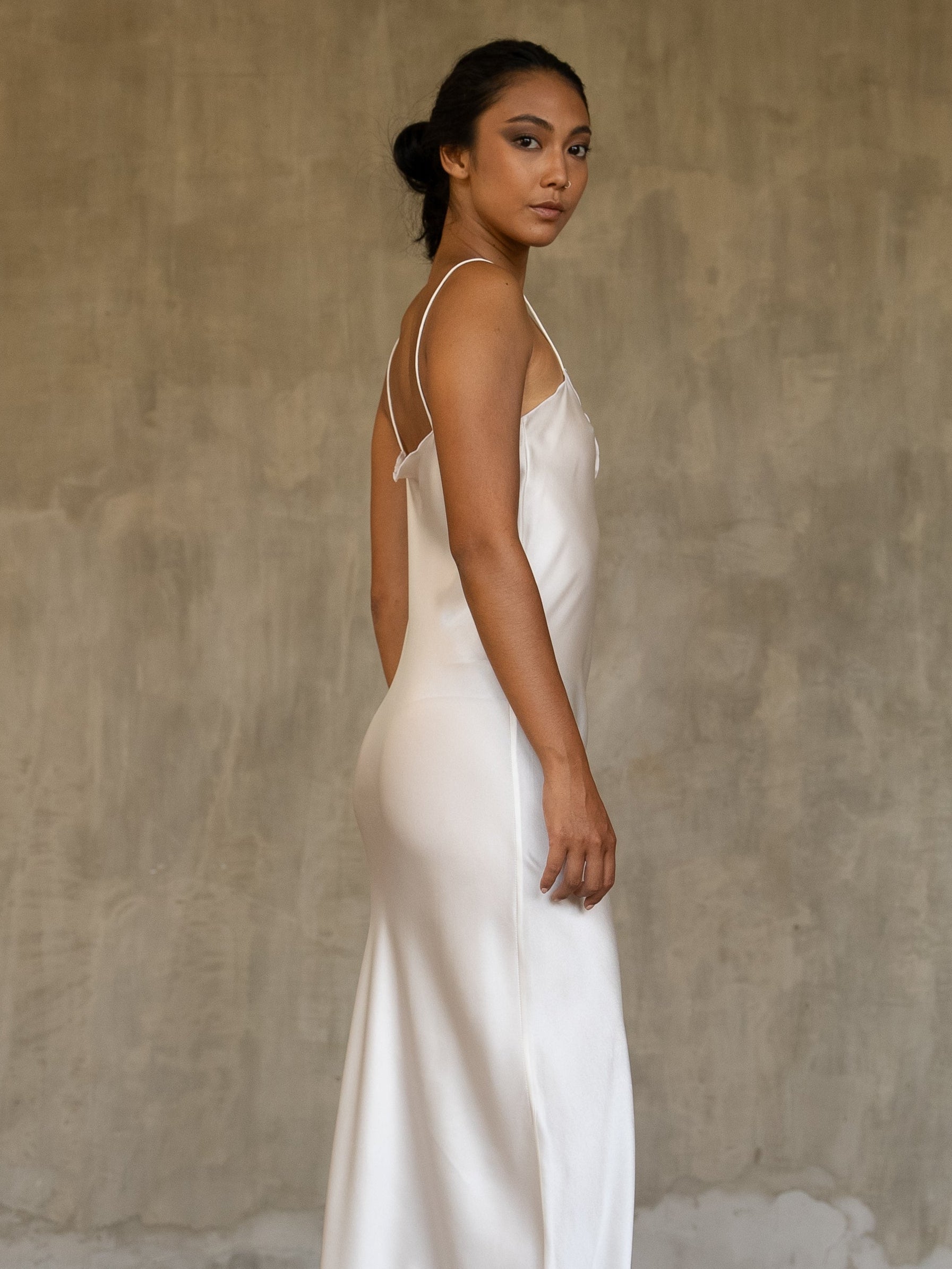 Side detail: this full length slip dress is cut on the bias, allowing a natural drape on the body which is complimented by the delicate spaghetti straps and the gentle, low-cut V-neckline. 