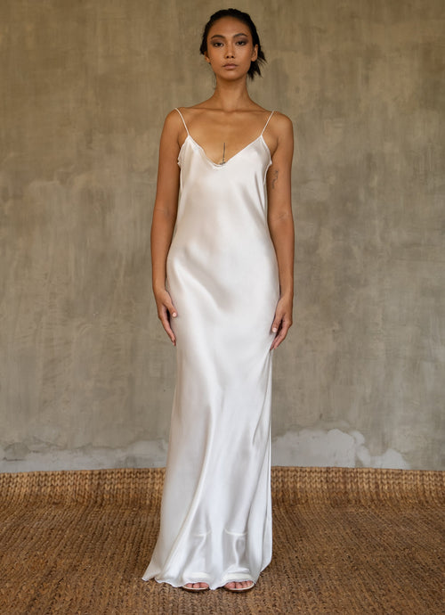 This full length slip dress is cut on the bias, allowing a natural drape on the body which is complimented by the delicate spaghetti straps and the gentle, low-cut V-neckline. 