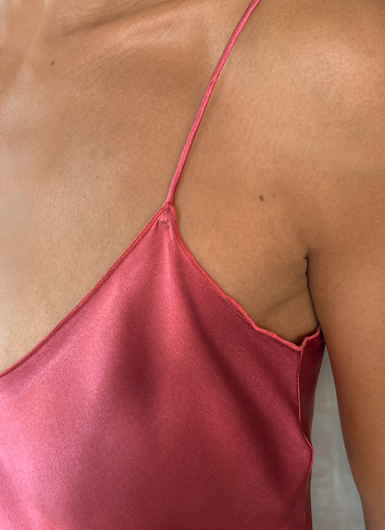 Detail of shoulder: Silk satin handcrafted long spaghetti dress in pink with maxi foliage pattern front and back. Bias cut dress with low V-neckline.