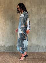 Load image into Gallery viewer, side detail: Silk satin handpainted asymmetric long dress in Greenwall botanical pattern in light blue background and darker leaves .
