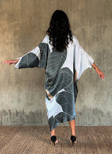Load image into Gallery viewer, Back detail: Silk satin handpainted asymmetric long dress in Greenwall botanical pattern in light blue background and darker leaves .
