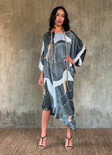 Load image into Gallery viewer, Silk satin handpainted asymmetric long dress in Greenwall botanical pattern in light blue background and darker leaves .
