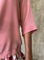 detail of a round neck pink top in silk crepe on top of knees long pant batik decorated by Bali artisan
