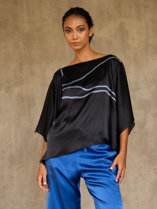 woman square top in silk satin black with blue lines wear on a blue bright pant