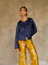 Load image into Gallery viewer, woman short jacket made in silk batik with stripes motif blue and light blue wear on top of a long silk pant yellow gold with withe floral motif
