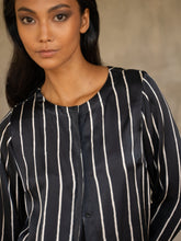 Load image into Gallery viewer, woman wearing short silk jacket black and white on a silk black pant with floral motif
