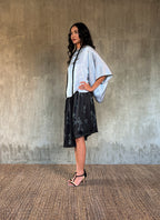 woman silk satin top hand painted in Bali in batik style and dark grey skirt with flower pattern