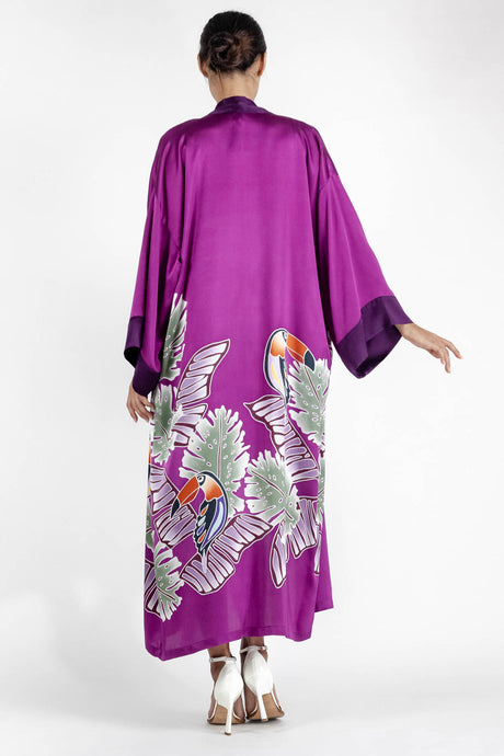 Back detail: Quarzia signature Kimono has wide, flowing sleeves and it's handcrafted from pure silk satin. As Japanese style' kimono  it is open under the arms. A bold contrast color border on the cuffs and on the front, together with the same color silk belt, frame this elegant piece, ultimate in relaxed style, elegance and comfort. The batik pattern is inspired by the incredible balinese leafy jungle and colorful tucans beauty.