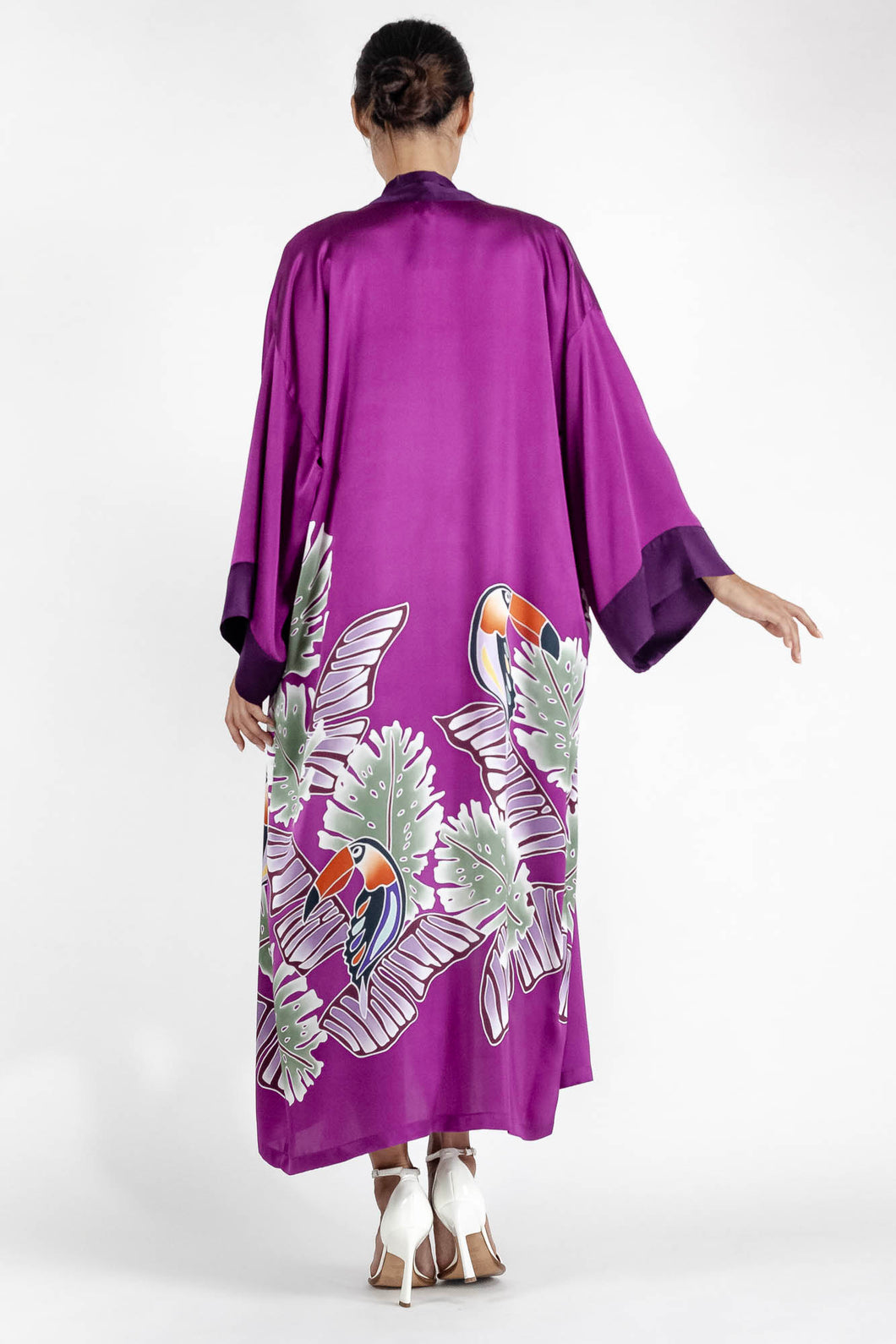 Back detail: Quarzia signature Kimono has wide, flowing sleeves and it's handcrafted from pure silk satin. As Japanese style' kimono  it is open under the arms. A bold contrast color border on the cuffs and on the front, together with the same color silk belt, frame this elegant piece, ultimate in relaxed style, elegance and comfort. The batik pattern is inspired by the incredible balinese leafy jungle and colorful tucans beauty.